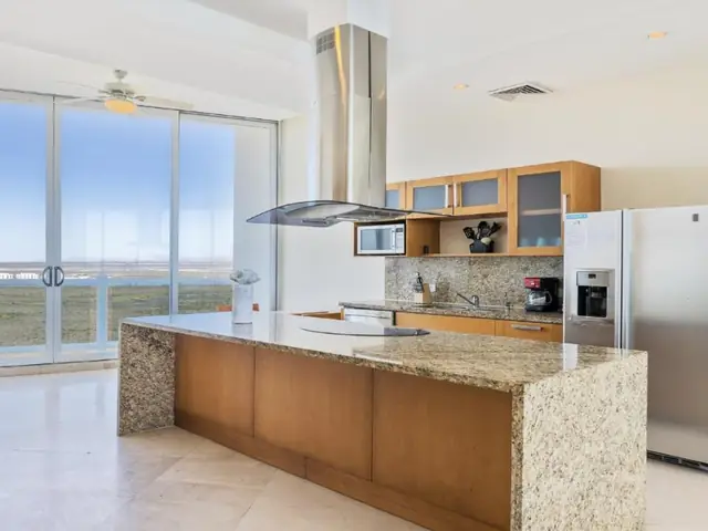 Penthouse kitchen with a granite island and a picture window facing the ocean